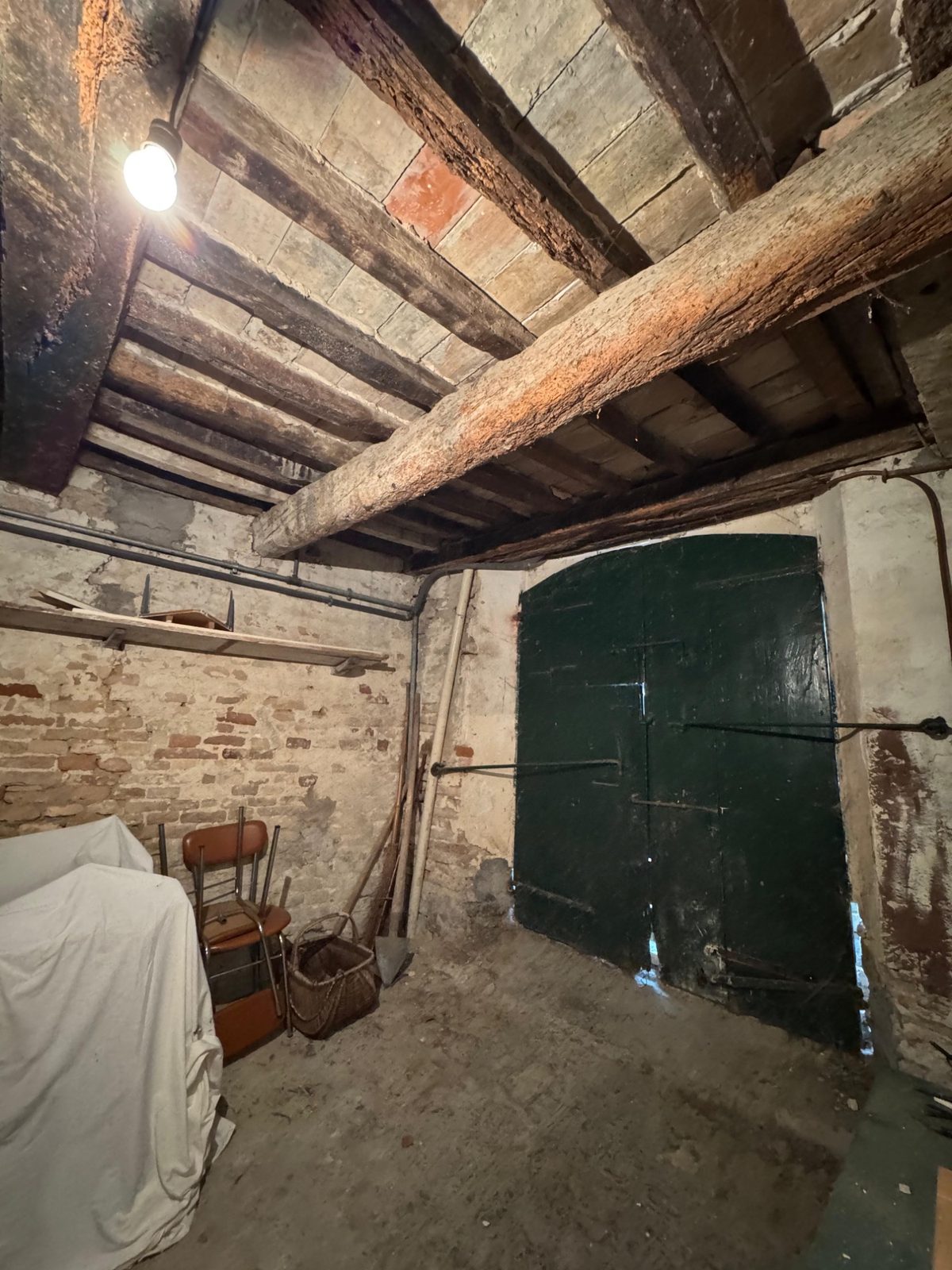 Piano terra prima del restauro: travi in legno e muratura storica